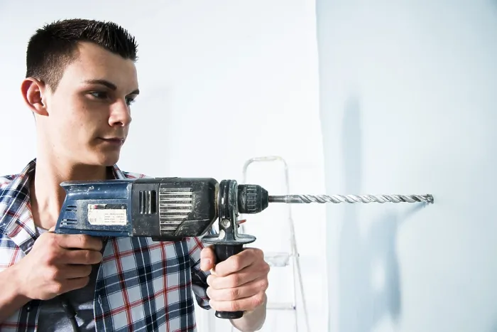 Framed Print : Young man using a drill