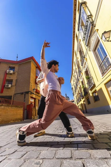 Framed Print : Two young men engaging in an energetic dance performance on a sunny historic cobblestone street