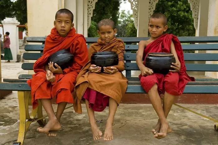 Framed Print : Young monks with rice bowls sitting on a bench