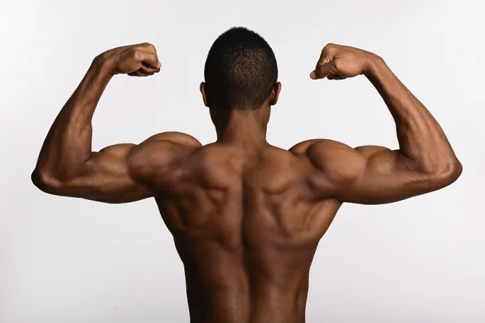 Framed Print : Young muscular African man shirtless flexing both arms isolated against white background