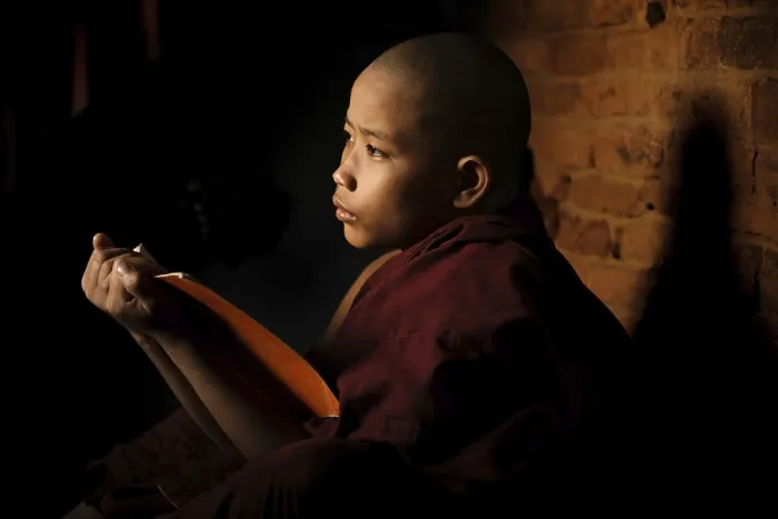 Framed Print : Young novice monk learning inside monastery