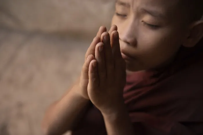 Framed Print : Young novice monk praying inside Buddhist temple Framed Print : Young novice monk praying inside Buddhist temple