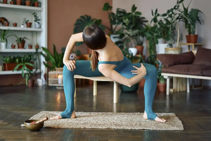 Framed Print : Young sporty woman practicing yoga at home doing twisting variation exercise of goddess pose