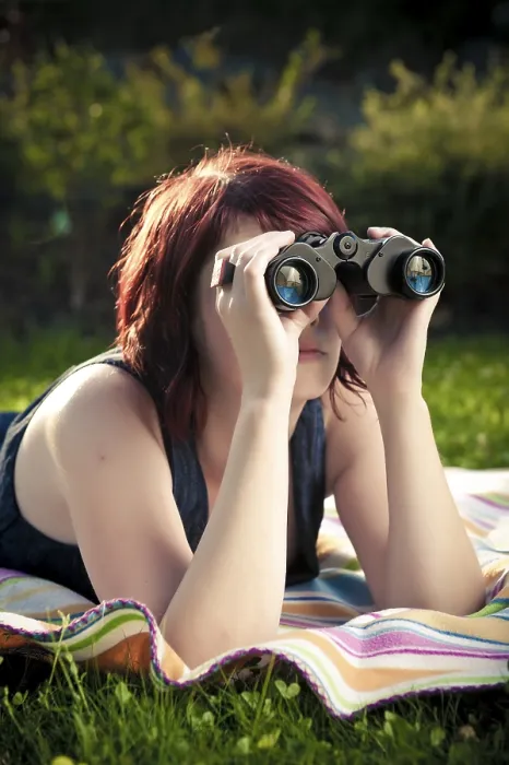 Framed Print : Young woman on a blanket in a meadow looking though binoculars Framed Print : Young woman on a blanket in a meadow looking though binoculars