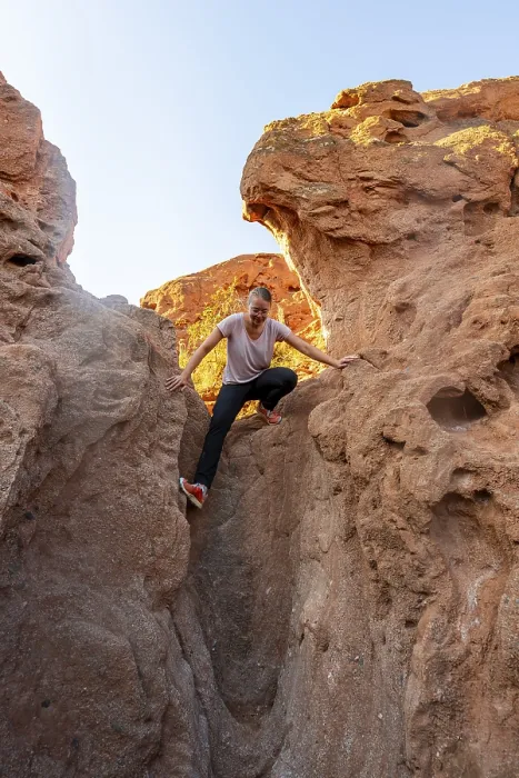 Framed Print : Young woman climbing between red sandstone rocks