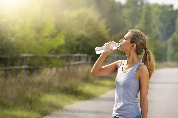 Framed Print : Young woman drink water while jogging outdoors