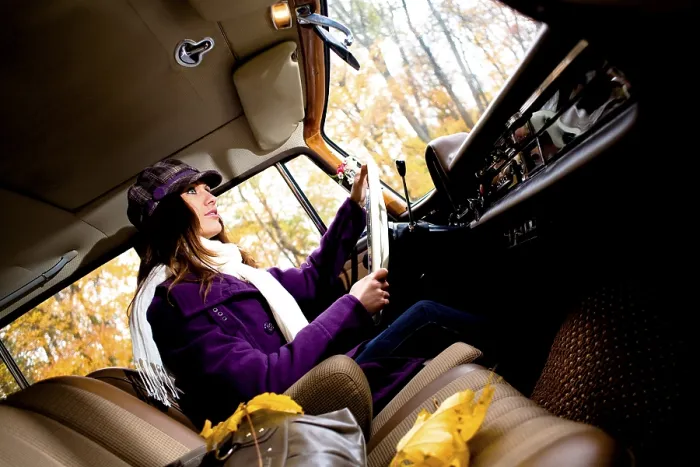 Framed Print : Young woman driving a vintage car
