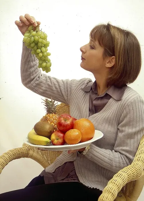 Framed Print : Young woman with grapes and fruit plate Framed Print : Young woman with grapes and fruit plate