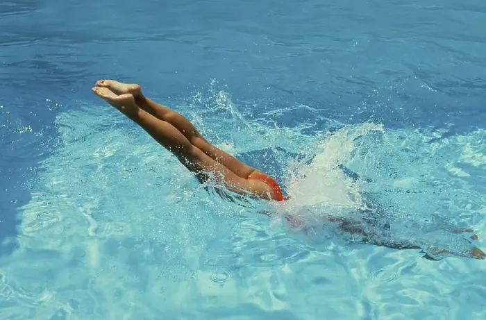 Framed Print : Young woman jumps into the swimming pool