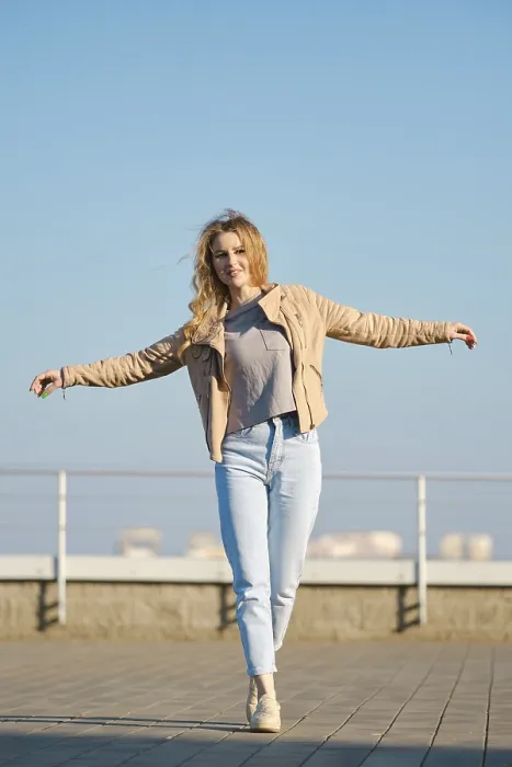 Framed Print : A young woman with long, flowing hair strides across a rooftop terrace on a clear