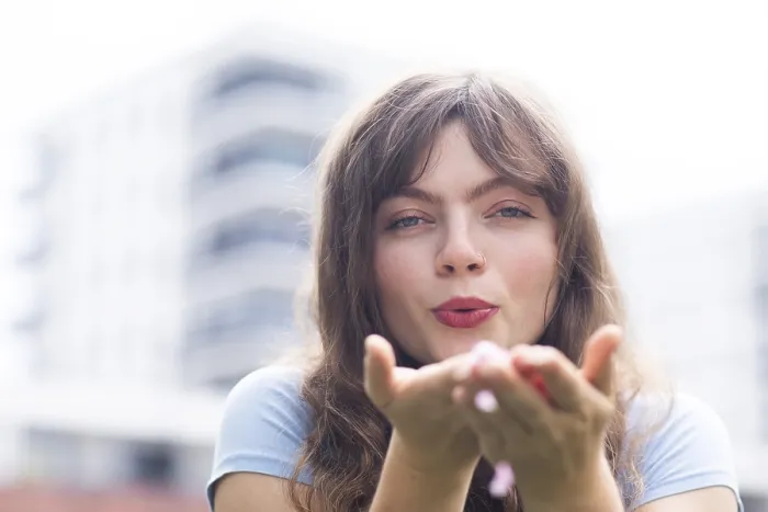 Framed Print : Young woman with long hair blowing into her hands