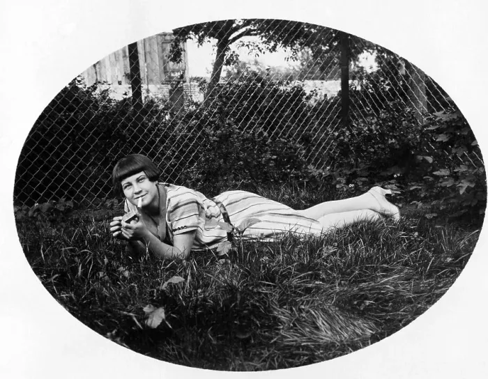 Framed Print : Young woman lying in the grass smoking