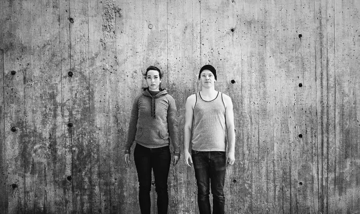 Framed Print : Young woman and man standing in front of concrete wall Framed Print : Young woman and man standing in front of concrete wall