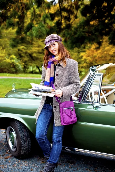 Framed Print : Young woman with a newspaper leaning against a vintage car Framed Print : Young woman with a newspaper leaning against a vintage car