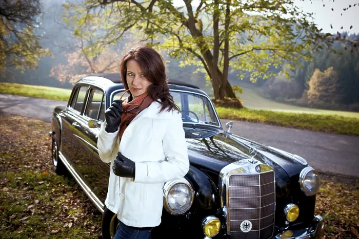Framed Print : Young woman in front of post-war classic car