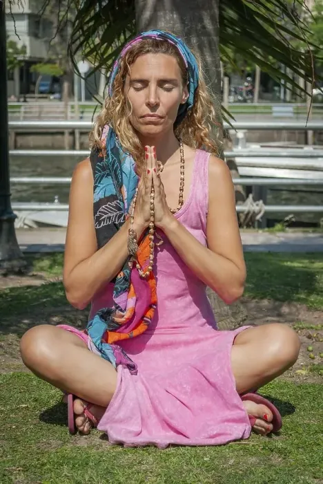 Framed Print : Young woman sitting cross-legged while meditating with her hands clasped outdoors