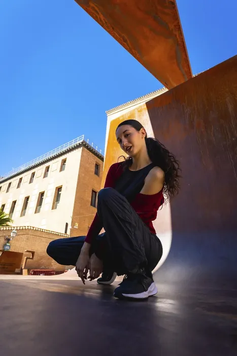 Framed Print : Young woman squatting on an urban surface Framed Print : Young woman squatting on an urban surface