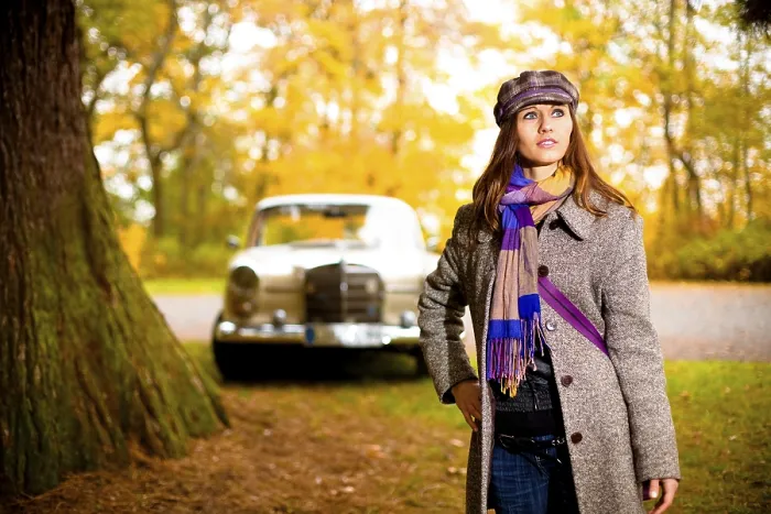 Framed Print : Young woman standing in front of a vintage car
