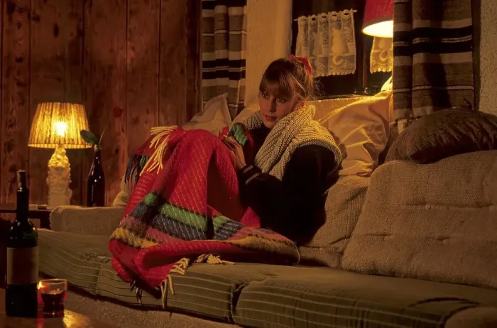 Framed Print : Young woman warmly dressed in the flat with blanket on the couch