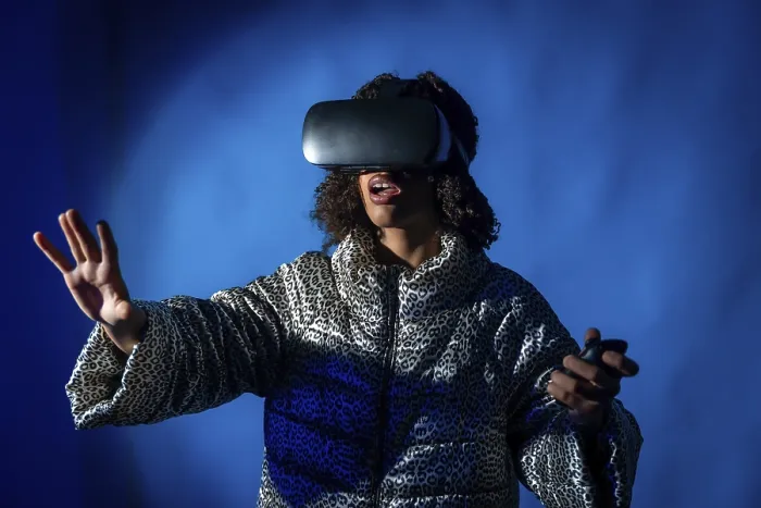 Framed Print : Young woman wearing a vr headset and holding controllers