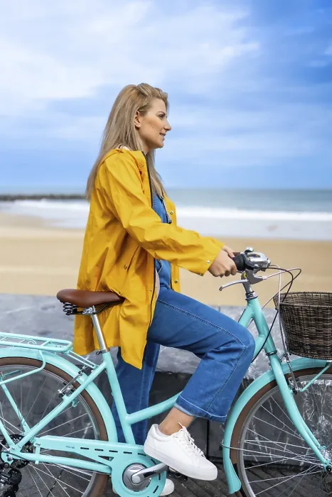 Framed Print : Young woman wearing yellow raincoat sitting on her light blue bicycle