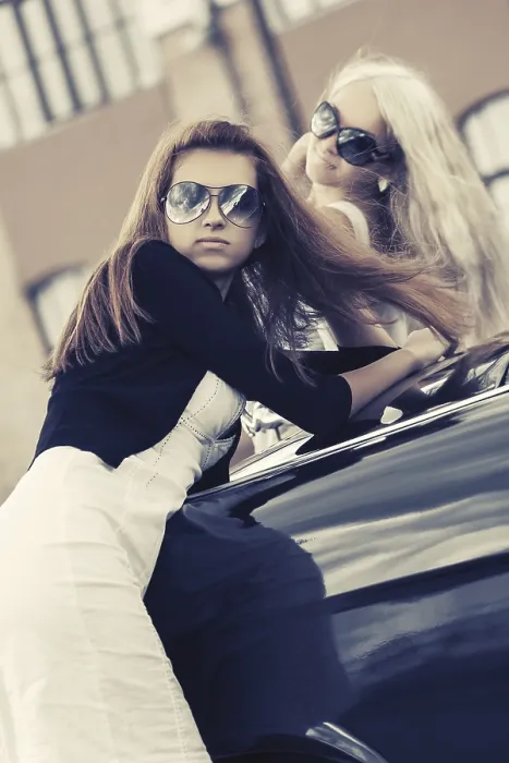 Framed Print : Two young women leaning on the vintage car in city street Framed Print : Two young women leaning on the vintage car in city street