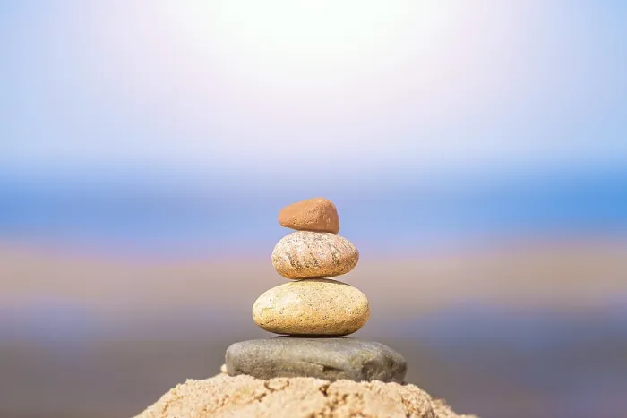 Framed Print : Zen balanced small pile of stacked stones on the beach in summer