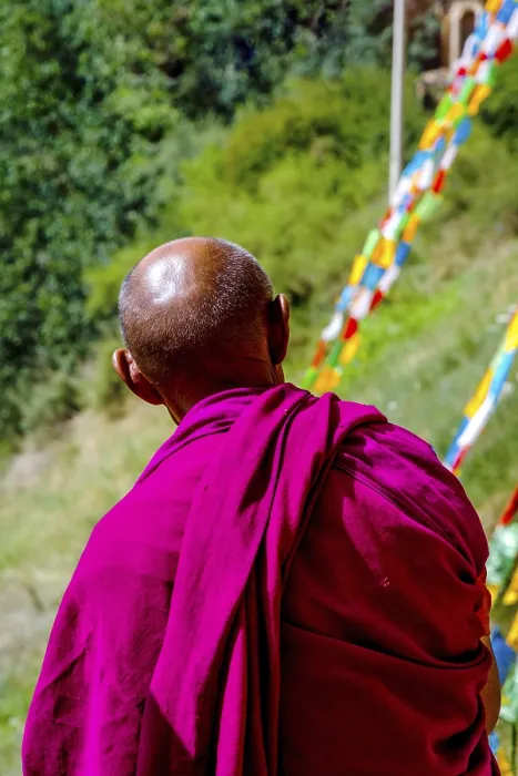 Framed Print : ZHANGYE, CHINA - JUNE 26: Old buddhist monk looking at colorful praying flags by Mati Si cave temple near Zhangye Framed Print : ZHANGYE, CHINA - JUNE 26: Old buddhist monk looking at colorful praying flags by Mati Si cave temple near Zhangye