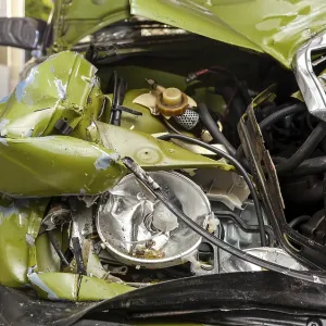 Accident, Car crash collision. Closeup shot of a crashed oldtimer cars front with demolished headlight Accident, Car crash collision. Closeup shot of a crashed oldtimer cars front with demolished headlight