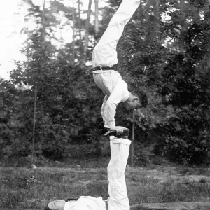 Two acrobats training on the meadow Two acrobats training on the meadow
