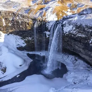 Aerial drone view of frozen Seljalandsfoss waterfall with snow in Iceland Aerial drone view of frozen Seljalandsfoss waterfall with snow in Iceland