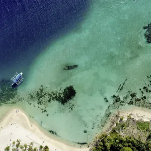 Une vue aérienne capture deux bateaux flottant sur la mer claire.