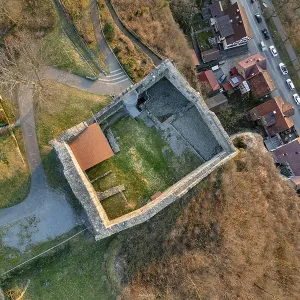 Aerial view of a castle ruins with adjacent streets and houses