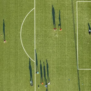 Aerial view, soccer practice, players casting long shadows
