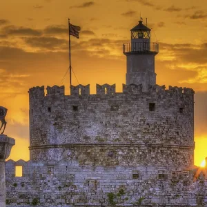 Agios Nikolaos fortress, historic castle with statue in front of a warm sunrise sky