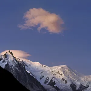 Aiguille du Midi snow-covered from left with sun-lit cloud over the summit Aiguille du Midi snow-covered from left with sun-lit cloud over the summit