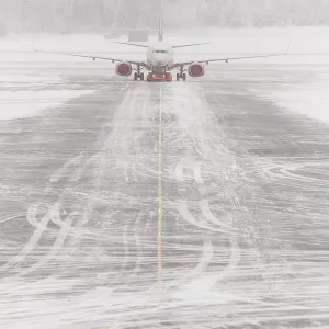 Airplane in bad weather, snow storm on snowy runway