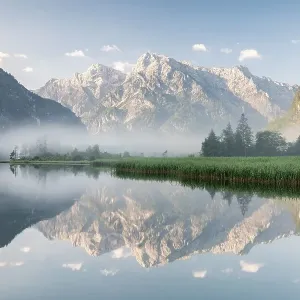 Alpine lake with reflection, fog atmosphere Alpine lake with reflection, fog atmosphere