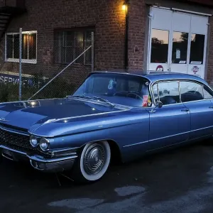 American classic car, blue Cadillac in front of red brick building