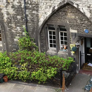 Arched windows and greenery frame the entrance of a residence quarters inside at The Tower of London