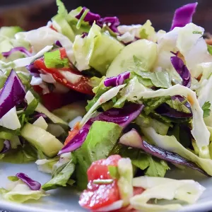 A assorted salad with cucumbers and purple leaflets
