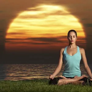An athletic, beautiful woman practising yoga on the beach at dawn An athletic, beautiful woman practising yoga on the beach at dawn