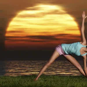 An athletic, beautiful woman practising yoga on the beach at dawn An athletic, beautiful woman practising yoga on the beach at dawn