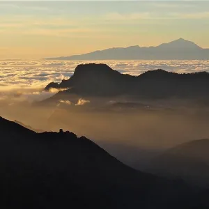 Atmospheric mountain scenery at sunset over a sea of clouds Atmospheric mountain scenery at sunset over a sea of clouds
