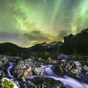 Aurora borealis over landscape with small river near the Sethaugelva lake in Tromvik