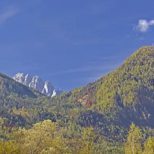 Autumn alpine slopes with round and jagged peaks under clear