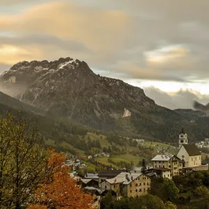 Autumn landscape with colorful trees and snowy mountains in the background in Dolomites