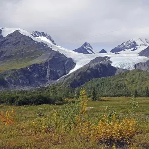Autumn landscape and a glacier calving deep into the valley Autumn landscape and a glacier calving deep into the valley