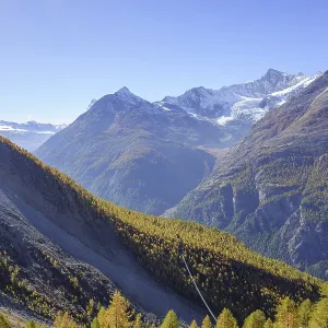 Autumn mountain landscape with wooded valley and alpine panorama