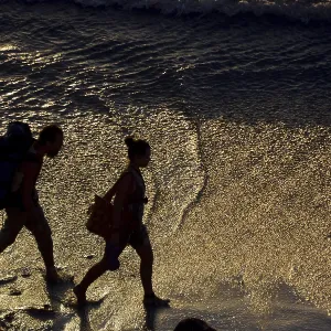 Two backpackers walking along the beach